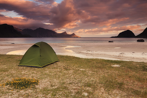Wild camping during the midnight sun on a Norwegian beach.
