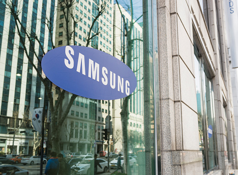 Seoul, Republic of Korea - March 26, 2013: The Samsung logo on the window of one of the South Korean company's offices in Gangnam, central Seoul, with cars and people on the street reflected  in the window.