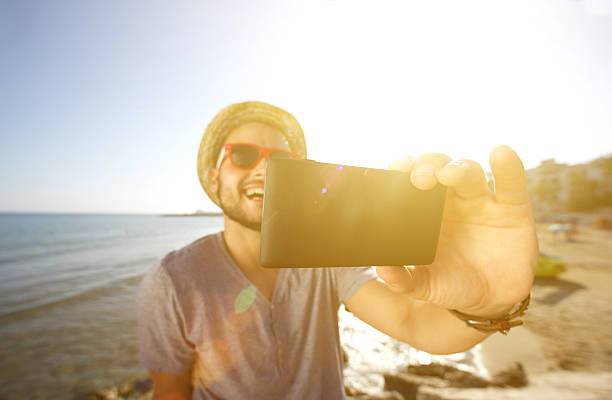 istock Happy man on vacation taking a selfie at the beach 484014306