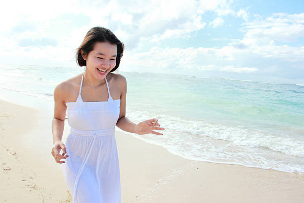 Small girl making heart with her hands on the beach