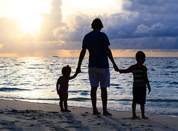 istock father and two kids walking at sunset 484015120