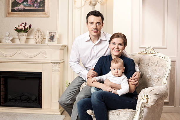 Young happy family with a baby indoors stock photo