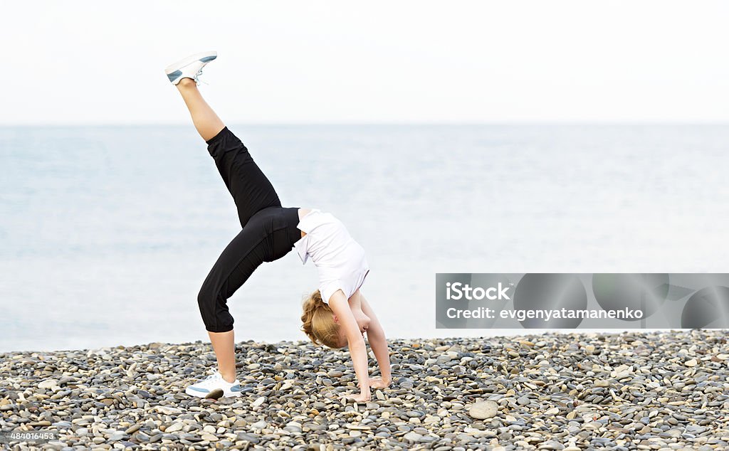 Mujer haciendo ejercicios de yoga y Deporte en la playa - Foto de stock de Adulto libre de derechos