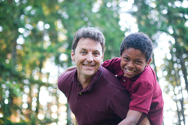A cute multi racial father and son playing outdoors in the evening light.