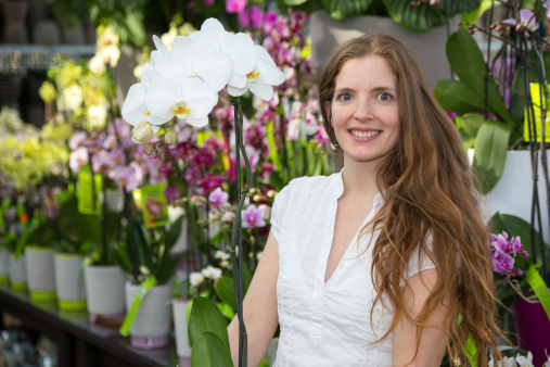 Customer in flower shop posing with an orchid