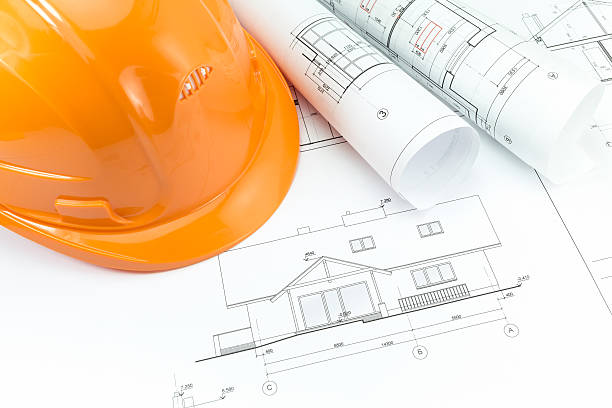 istock Orange helmet and rolls of blueprints 484017389
