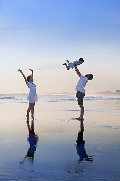 istock Positive family having fun on black sand sea beach 484022606