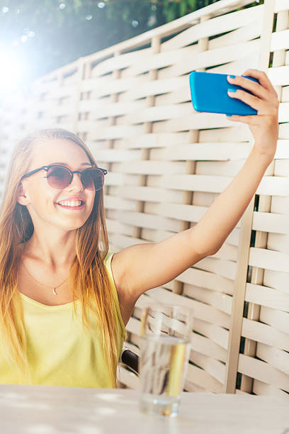 istock Young girl with a sunglasses making selfie 484025646