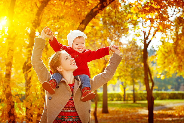 família feliz: mãe e criança pequena filha jogam cuddling em - child autumn nature human face - fotografias e filmes do acervo