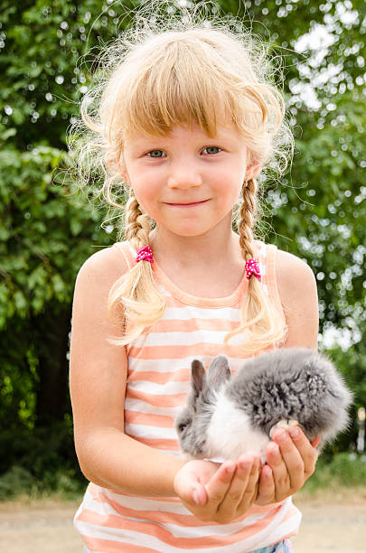 istock girl with young bunny rabbit 484027722