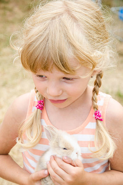 istock blond girl with young bunny rabbit 484027736