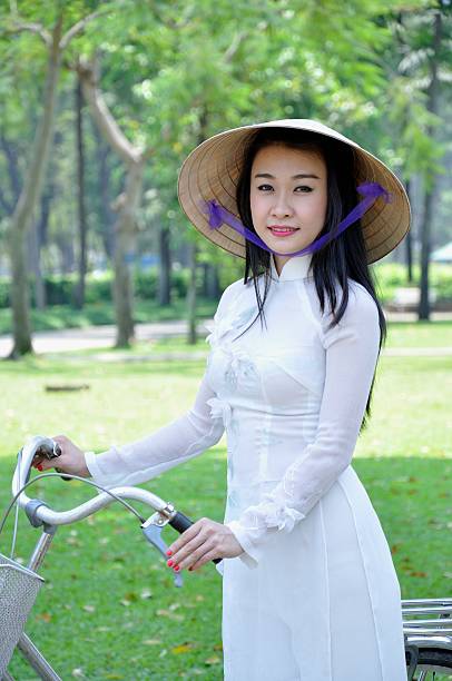 Vietnamese girl Vietnamese girl ware white Ao dai (Vietnam nation dress) with bicycle ao dai stock pictures, royalty-free photos & images