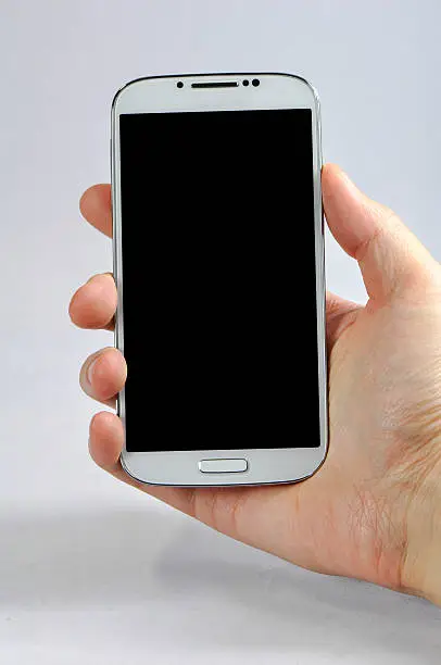 Photo of Holding a smart phone with blank screen isolated on white