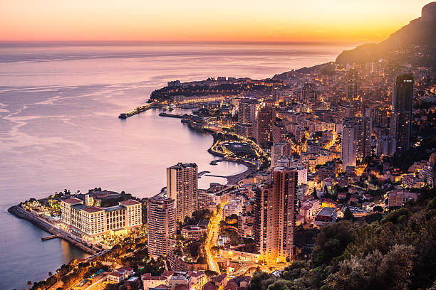 Monaco city illuminated aerial view Panorama view of monaco city, harbour, sea, beach and rock at sunset. illuminated by the sun and lights of the place. beautiful colours and scenic picture of this famous place. monaco photos stock pictures, royalty-free photos & images