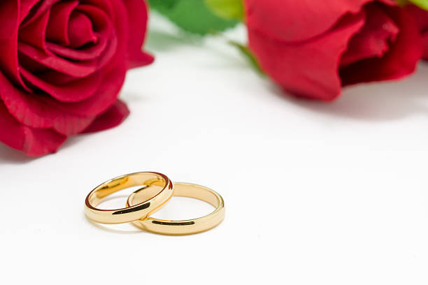 istock Wedding rings and artificial rose on white background 484033118