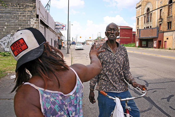 Detroit, Michigan - May 26, 2010: A man and woman argue on a street in Detroit in front of the abandoned Eastown Theatre.