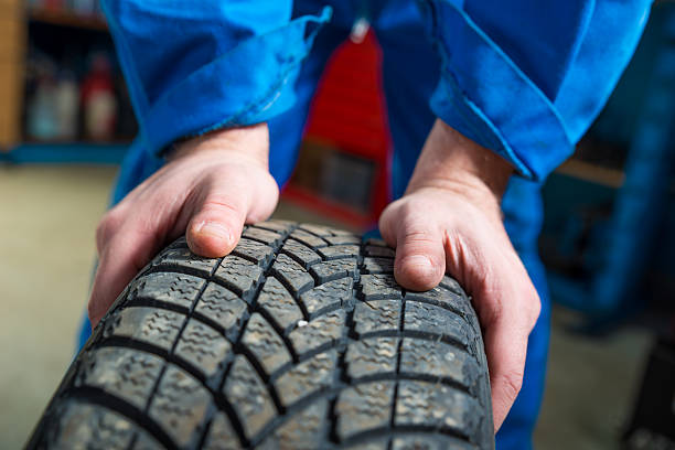 istock Mechanic fixing tyre in car service 484033527