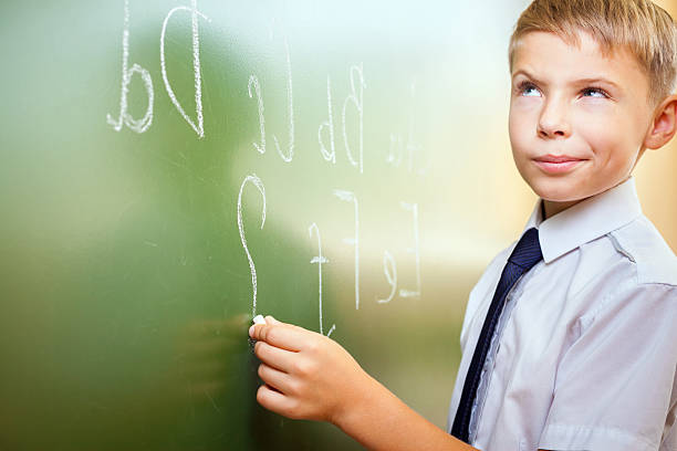 istock School boy writes English alphabet with chalk on blackboard 484033982
