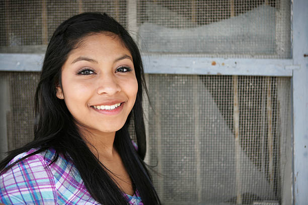 A teenage girl by an old screen window