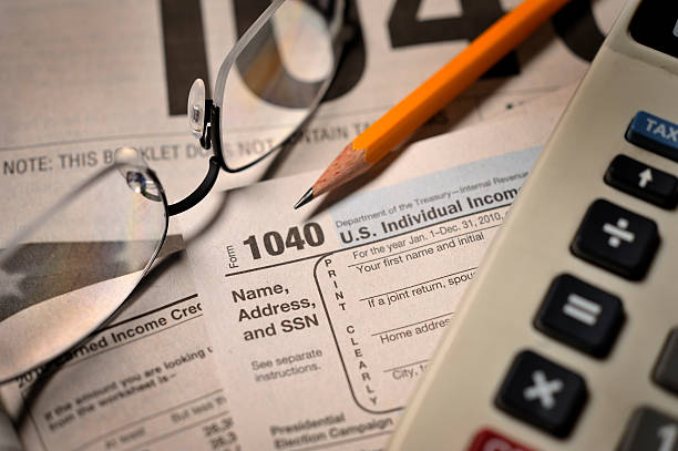 szafa podatków na wypełnionym formularzem udostępnianym przez urząd podatkowy 1040 zbliżenie widok - tax tax form financial advisor calculator zdjęcia i obrazy z banku zdjęć