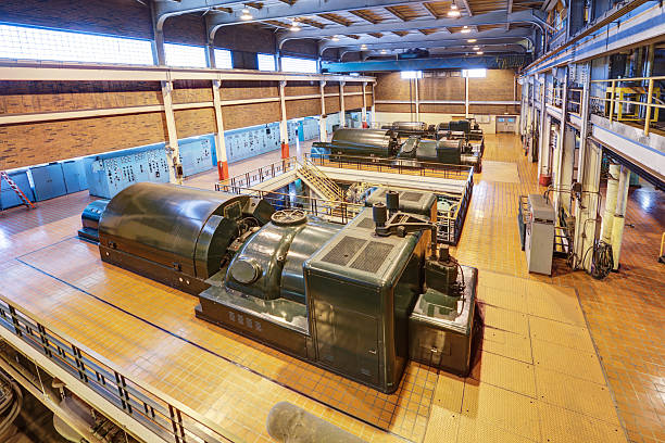 Row of hydro-power generators working at a dam. The huge turbines in these generators turn as the water blasts through, creating electricity.