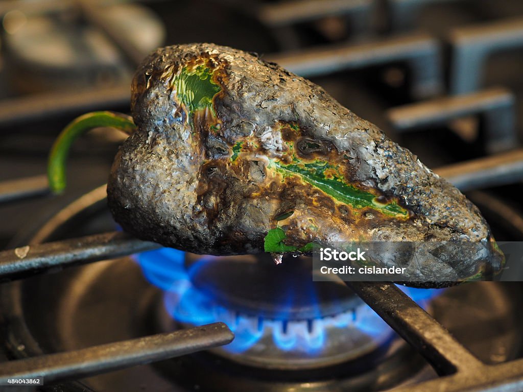 Chile Roasting on open burner Preparing a chile for peeling and eventual stuffing. Poblano Chili Stock Photo