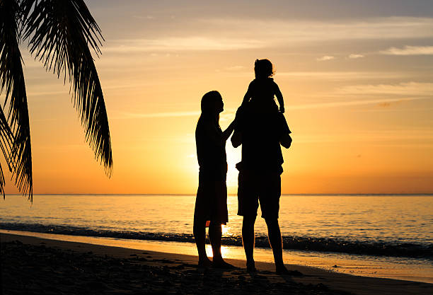 istock romantic couple with little child at sunset beach 484044564