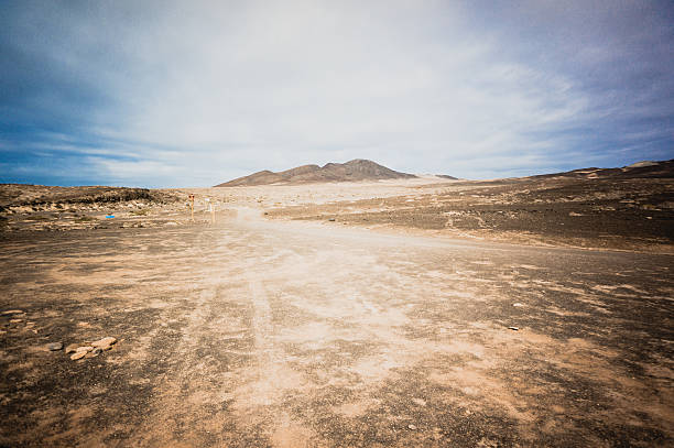 mezzo di un deserto - dirt road road desert road gravel foto e immagini stock