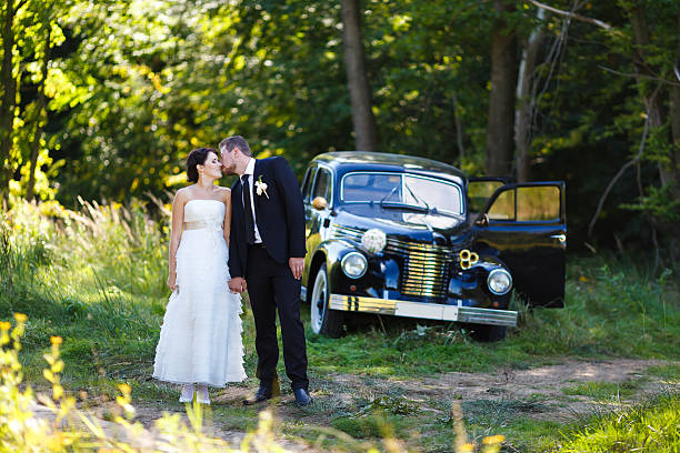 istock Wedding couple with old car 484048714