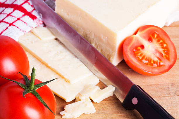 istock Tomatoes and cheese with knife on chopping board 484057670