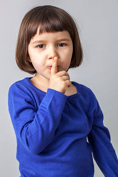 istock smiling 3 years old girl expressing a secret 484059440