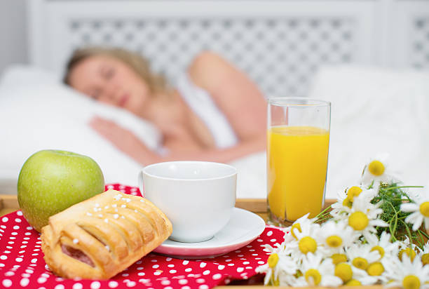 istock Breakfast in bed. Sleeping woman on background. 484062848