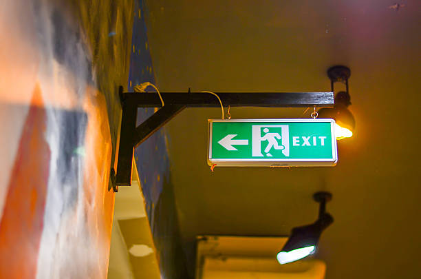 iluminado verde sinal de saída - people metal sign way out sign imagens e fotografias de stock
