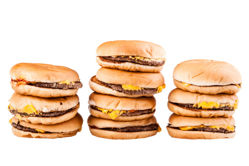 a very tall pile of cheesburgers isolated over a white background