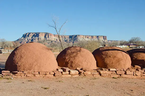 Hornos, or ovens used to bake bread, are lined up in a row in the Zuni Pueblo in west central New Mexico.  In the background is Dowa Yalanne (Corn Mountain) where the Zuni people fled to escape Coronado's expedition in 1540.