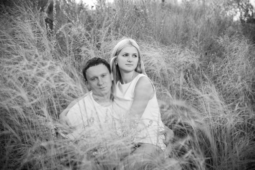 Loving couple on grass in summer. Black and white photography