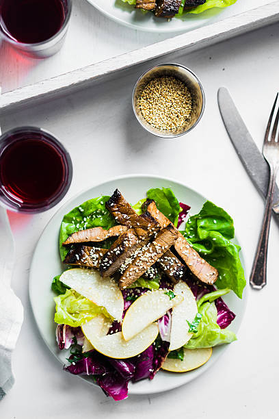 istock Sliced meat steak with green salad and pears 484066580