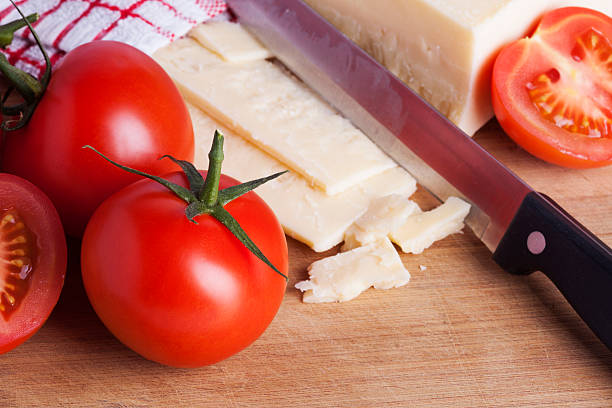 istock Tomatoes and cheese with knife on chopping board 484067226