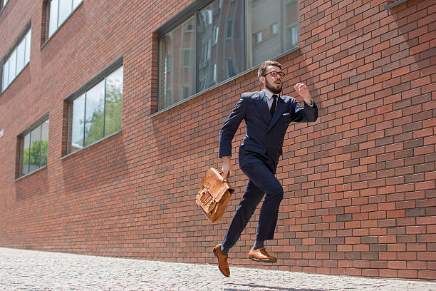 若いビジネスマンのランニングで、街の通り - businessman checking the time men male ストックフォトと画像