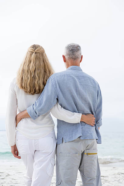 istock Happy couple hugging each other and looking at the sea 484068584