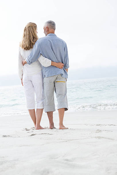 istock Happy couple hugging each other and looking at the sea 484068666