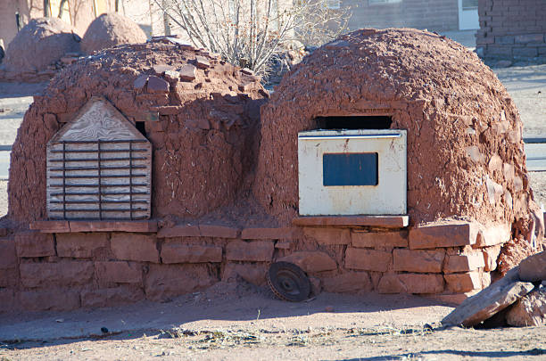 Hornos at Zuni Pueblo Hornos, or ovens used to bake bread, are lined up in a row in the Zuni Pueblo in west central New Mexico. These two have unusual covers:  one is an oven shelf attached to wood and the other is an actual oven door! stove oven adobe outdoors stock pictures, royalty-free photos & images