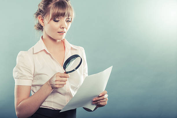 istock woman uses magnifying glass to check contract 484068890