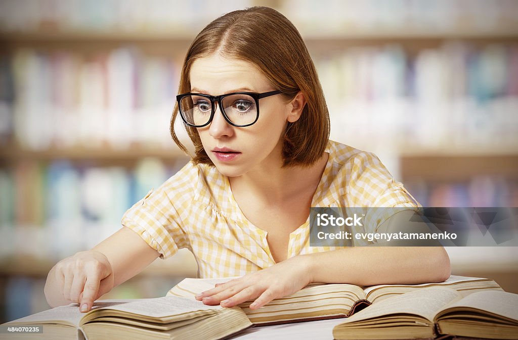 Śmieszne zaskoczony dziewczynka z okulary Czytanie książek - Zbiór zdjęć royalty-free (Biblioteka)