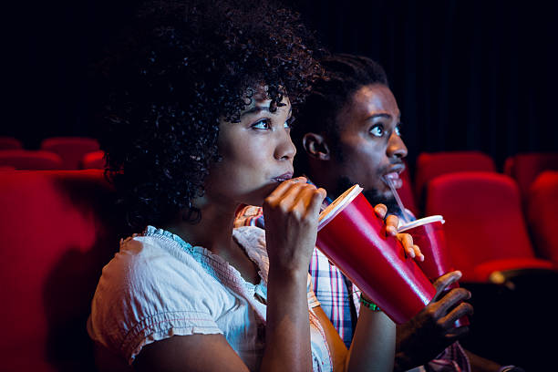 Young couple watching a film Young couple watching a film at the cinema date fruit stock pictures, royalty-free photos & images