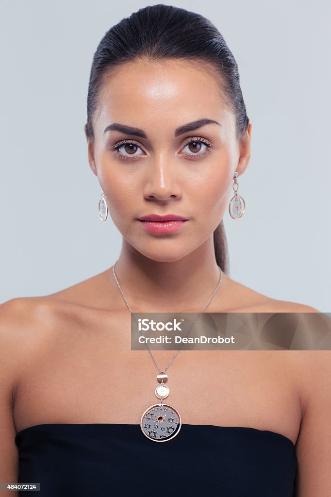 Portrait of a charming fashion woman Jewerly concept. Portrait of a charming fashion woman on gray background. Looking at camera 2015 Stock Photo