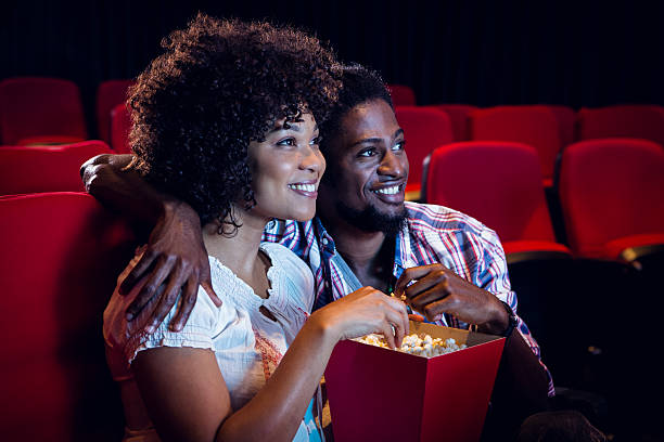 Happy young couple watching a film at the cinema