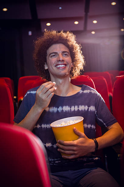 istock Smiling young man watching a film 484072898
