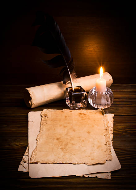 istock feather, old paper and candle on a wooden background 484078273