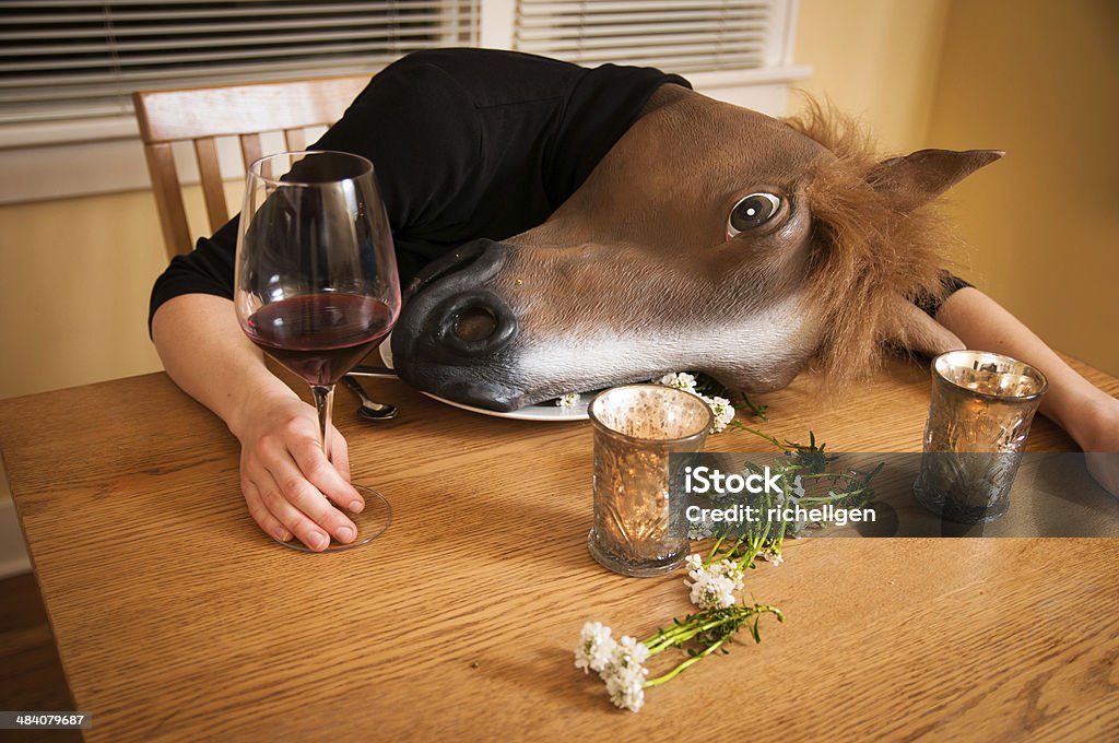 Passed out after dinner A horse man has had too much food and wine and lays down at the table with dinner salad on the table.  Unconscious Stock Photo